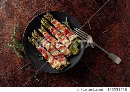 Grilled green asparagus wrapped in bacon. 126555936