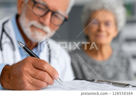 Senior doctor filling medical form for elderly patient Senior doctor filling medical form for elderly patient 126558384