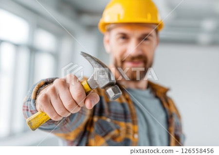 Handsome Worker Holding Tool and Smiling 126558456
