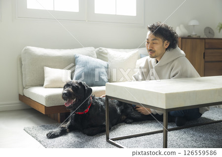 A man relaxing in the living room with his dog 126559586
