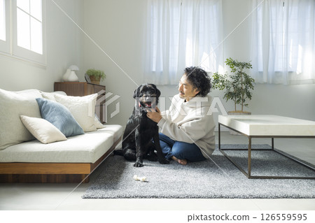 一位男士和他的狗在客廳休息 一位男士和他的狗在客廳休息 126559595
