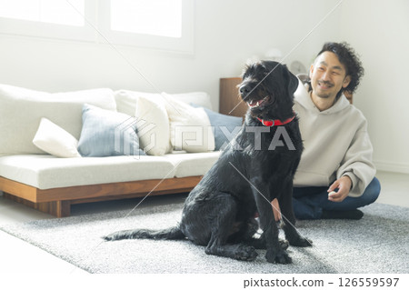 A man relaxing in the living room with his dog 126559597