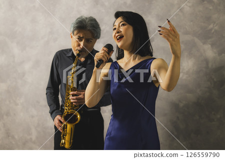 A man playing saxophone and a woman singing 126559790