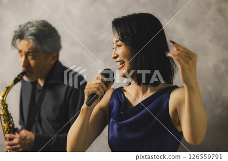 一名男子吹奏薩克斯,一名女子唱歌 一名男子吹奏薩克斯,一名女子唱歌 126559791