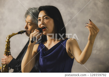 一名男子吹奏薩克斯，一名女子唱歌 126559792