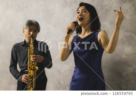 一名男子吹奏薩克斯，一名女子唱歌 126559793