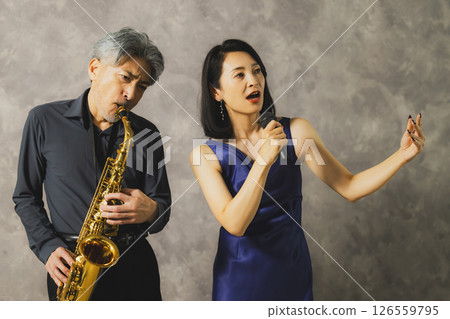 A man playing saxophone and a woman singing 126559795