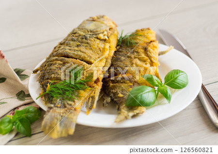 Traditional Ukrainian fried crucian carp in a village kitchen Traditional Ukrainian fried crucian carp in a village kitchen 126560821