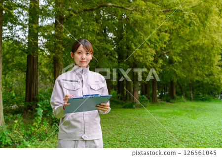 A woman in work clothes performing maintenance 126561045