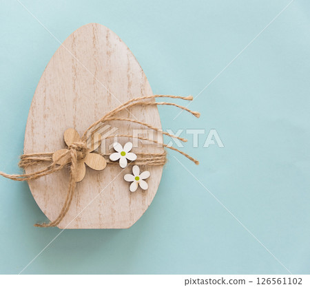Easter wood handmade egg on the blue background with copy space. Easter wood handmade egg on the blue background with copy space. 126561102