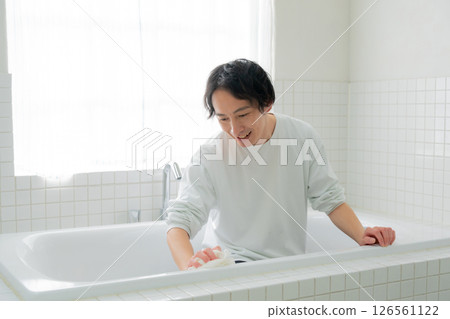 Man cleaning the bathtub 126561122