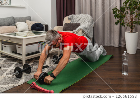 Individual doing workout on exercise mat at home 126561558