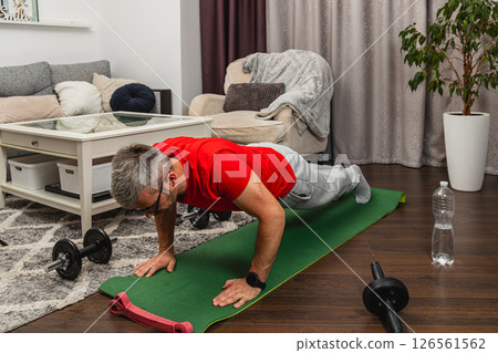 Man doing push-ups at home gym during workout session 126561562