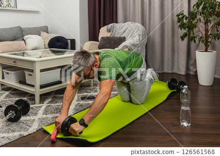 Home workout session with weights on a yoga mat 126561568