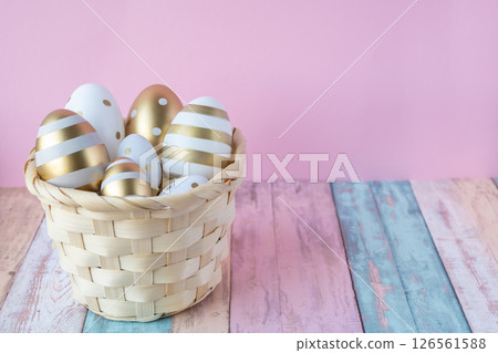 Gold Easter eggs in woven natural basket on a wood natural colors background. Easter concept for greeting card. 126561588