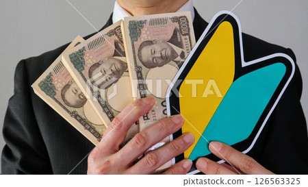 Businessman with beginner mark and banknotes 126563325
