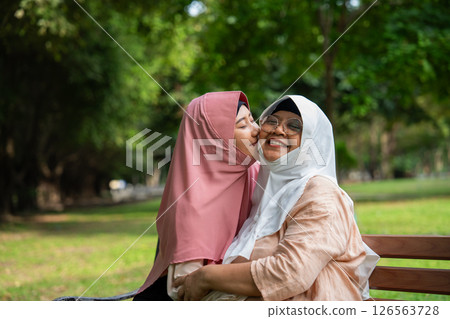 Muslim careful caregiver or nurse taking care of the patient in the hospital park. Happy Muslim mother in hijab hugging daughter. Concept of Savings and Senior Health Insurance, a Happy Family Muslim careful caregiver or nurse taking care of the patient in the hospital park. Happy Muslim mother in hijab hugging daughter. Concept of Savings and Senior Health Insurance, a Happy Family 126563728