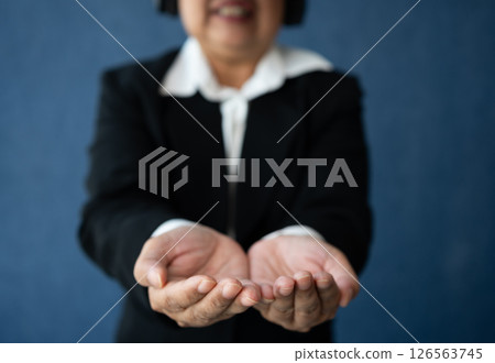 Senior Business woman wearing smart virtual glasses for Video conferences, VR  headset glasses technology in modern offices and open the palm of the hand. Metaverse concept. Senior Business woman wearing smart virtual glasses for Video conferences, VR  headset glasses technology in modern offices and open the palm of the hand. Metaverse concept. 126563745