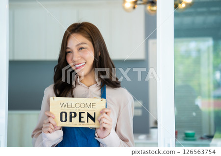 Portrait of Young Asian Barista hold open sign coffee shop restaurant, Smiling waitress or cafe business owner entrepreneur, asian business woman barista cafe owner SME entrepreneur selling concept 126563754