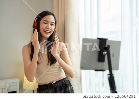 Asian women and beautiful bloggers wear headphones dancing videos by smartphone cameras. Creator vlogger talent dancing enjoys hobby content recording show video sharing on social media. Asian women and beautiful bloggers wear headphones dancing videos by smartphone cameras. Creator vlogger talent dancing enjoys hobby content recording show video sharing on social media. 126564291