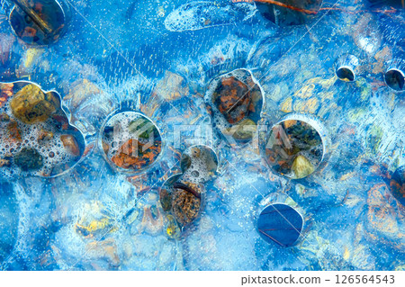 Melting spring ice on river filled with light and colors 126564543