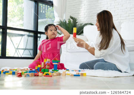 Cherry young mother plays colorful toy block with her Down syndrome daughter,  colorful wooden toys can increase skills and learning to increase the development, special education, Knowing slowly 126564724