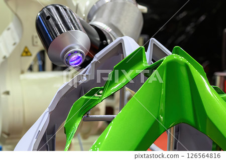 Close up scene the spray painting robot working with motorcycle parts. Close up scene the spray painting robot working with motorcycle parts. 126564816