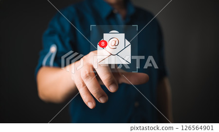 A person in a blurred background interacts with a virtual icon of an email envelope displaying eight notifications, symbolizing unread messages, digital communication, and email alerts. A person in a blurred background interacts with a virtual icon of an email envelope displaying eight notifications, symbolizing unread messages, digital communication, and email alerts. 126564901