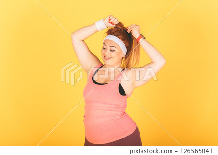 A woman in a pink tank top is doing a workout A woman in a pink tank top is doing a workout 126565041