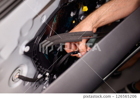 Hands Engaged in the Process of Performing Automotive Interior Repairs Effectively Hands Engaged in the Process of Performing Automotive Interior Repairs Effectively 126565206