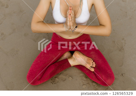 Close up namaste mudra. Yoga at the beach. Woman sitting on sand practicing yoga with namaste mudra. Meditation and concentration. Yoga concept. Thomas beach, Bali, Indonesia 126565329