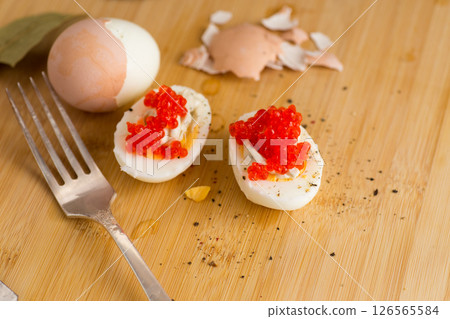 red caviar and boiled eggs on a wooden board 126565584