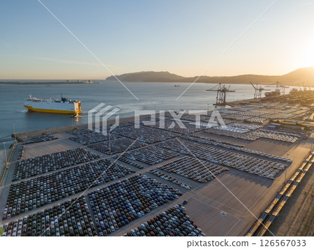 New Cars on Parking Lot and RORO cargo ship in Port of Setubal. Aerial View New Cars on Parking Lot and RORO cargo ship in Port of Setubal. Aerial View 126567033