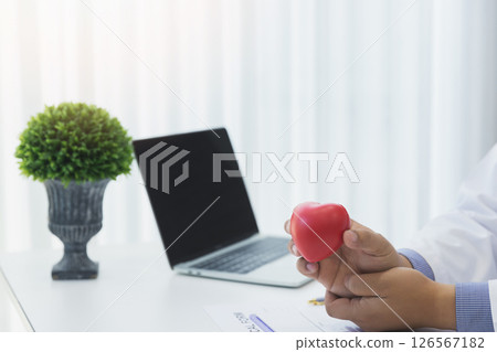 Doctor hands hold a red heart over office desk. Concept of health care and medical. Doctor hands hold a red heart over office desk. Concept of health care and medical. 126567182