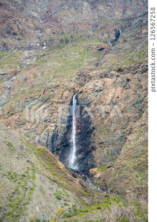 Mountain cliffs surrounding Chulyshman valley with visible waterfall Altai Russia Dramatic natural landscape with high rocks and falling water 126567258