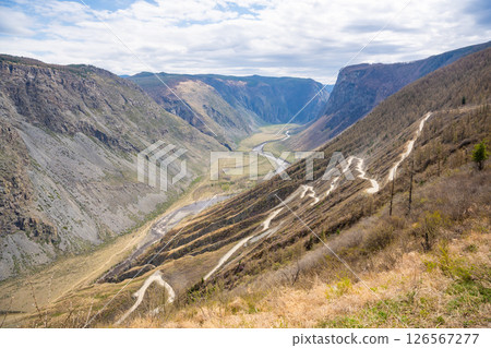 Top view of mountain road leading to Katu Yaryk pass and Chulyshman valley with river in Altai Russia Dramatic highland landscape with winding route and deep canyon 126567277
