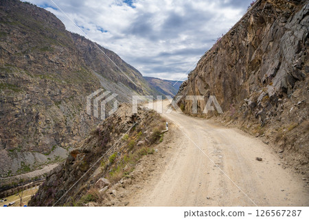 Gravel road winding through Katu Yaryk pass in Altai mountains Russia Mountain route connecting remote valley with highland plateau Gravel road winding through Katu Yaryk pass in Altai mountains Russia Mountain route connecting remote valley with highland plateau 126567287