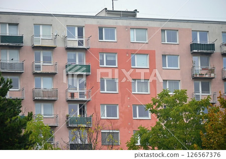 Original prefabricated houses on a housing estate from the communist era in Eastern and Central Europe after reconstruction.. Facade of a modern apartment building with windows and balconies. Czech 126567376