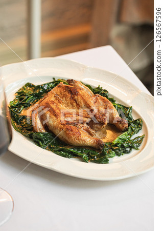 Portion of baked chicken with spinach 126567596