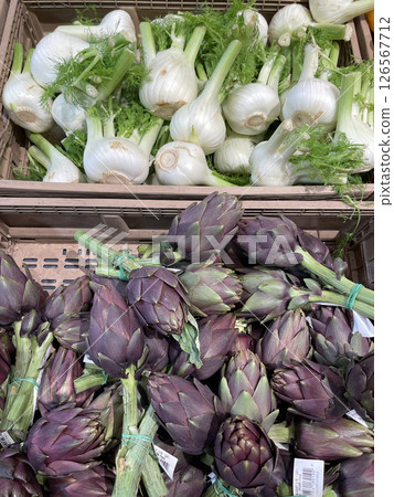 Artichoke, fennel in crates at market in Europe, Italy. Organic local food and health. Seasonal vegetables. Artichoke, fennel in crates at market in Europe, Italy. Organic local food and health. Seasonal vegetables. 126567712