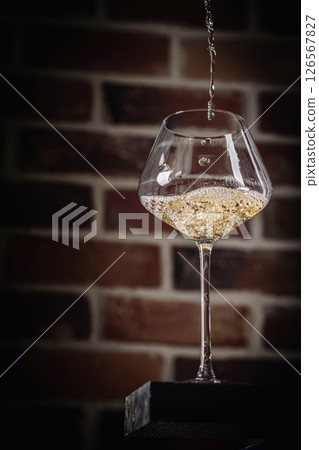 Pouring white wine Pouring white wine 126567827
