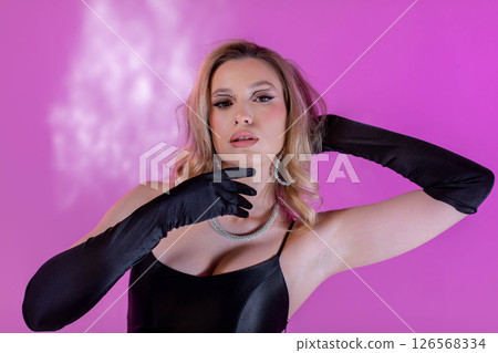 A Stylish Fashion Model Posing Gracefully with Glamorous Accessories on a Pink Background 126568334