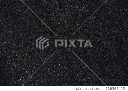 Background of porous foam rubber. Black foam rubber. Packaging material. 126568415