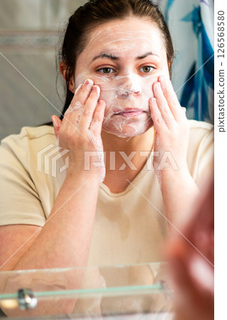 Morning skincare routine: woman doing first step of face skin cleansing routine. Relatable content for skincare. International self care day. Morning skincare routine: woman doing first step of face skin cleansing routine. Relatable content for skincare. International self care day. 126568580