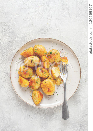 half-eaten fried new potatoes, with butter and dill, on a white plate, with a fork, at home, no people, 126569167