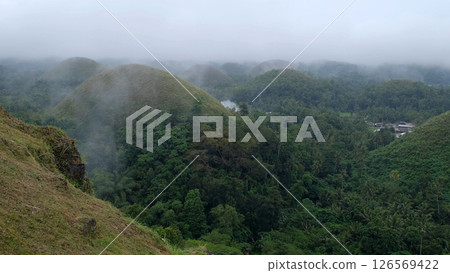 Misty Chocolate Hills on Bohol Island create a dreamy view as soft hills fade into rainy greenery Misty Chocolate Hills on Bohol Island create a dreamy view as soft hills fade into rainy greenery 126569422