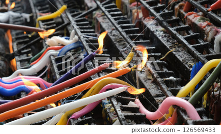 A range of colored candles burn on the altar of a Philippine church, each representing different prayers  126569433