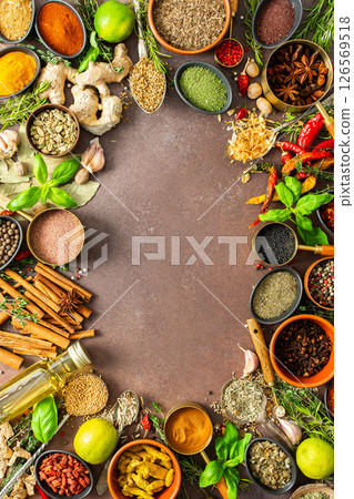A colorful assortment of fragrant herbs and spices on a warm brown background, showcasing their visual variety and aromatic appeal, spice frame A colorful assortment of fragrant herbs and spices on a warm brown background, showcasing their visual variety and aromatic appeal, spice frame 126569518