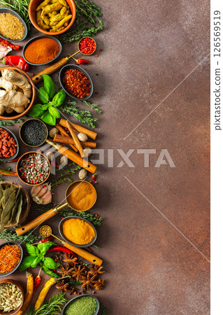 A harmonious mix of spices and herbs, bursting with colors and fragrances, spread on a warm brown background, evoking a sense of culinary artistry A harmonious mix of spices and herbs, bursting with colors and fragrances, spread on a warm brown background, evoking a sense of culinary artistry 126569519