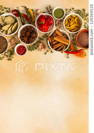 A colorful array of dried spices and fresh herbs arranged on a soft beige background, ideal for seasoning and adding rich flavor to dishes, top view and copy space A colorful array of dried spices and fresh herbs arranged on a soft beige background, ideal for seasoning and adding rich flavor to dishes, top view and copy space 126569520